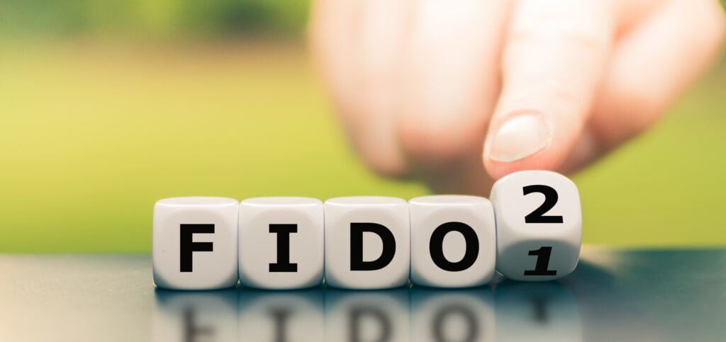 Illustration of FIDO authentication showing F I D O blocks and a finger switching a block from 1 to 2 to represent more secure and modern phishing-resistant login
